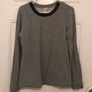 Metallic silver top with neckline embellishment.